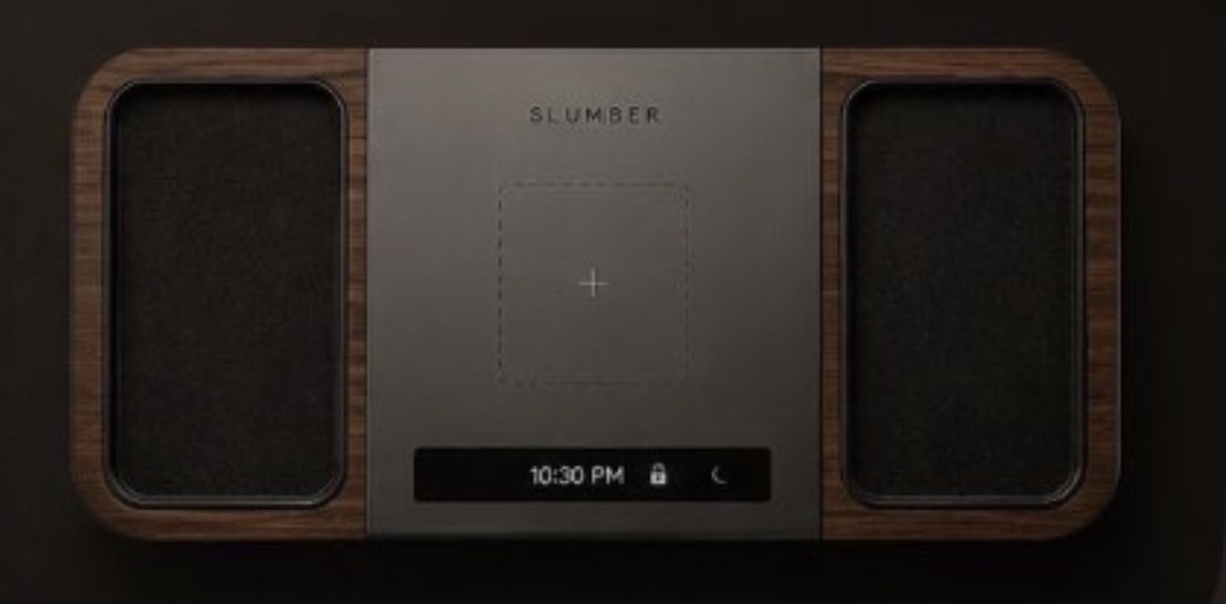 Slumber One seen from above — walnut valet trays either side of a smoked-glass charging deck reading 10:30 PM